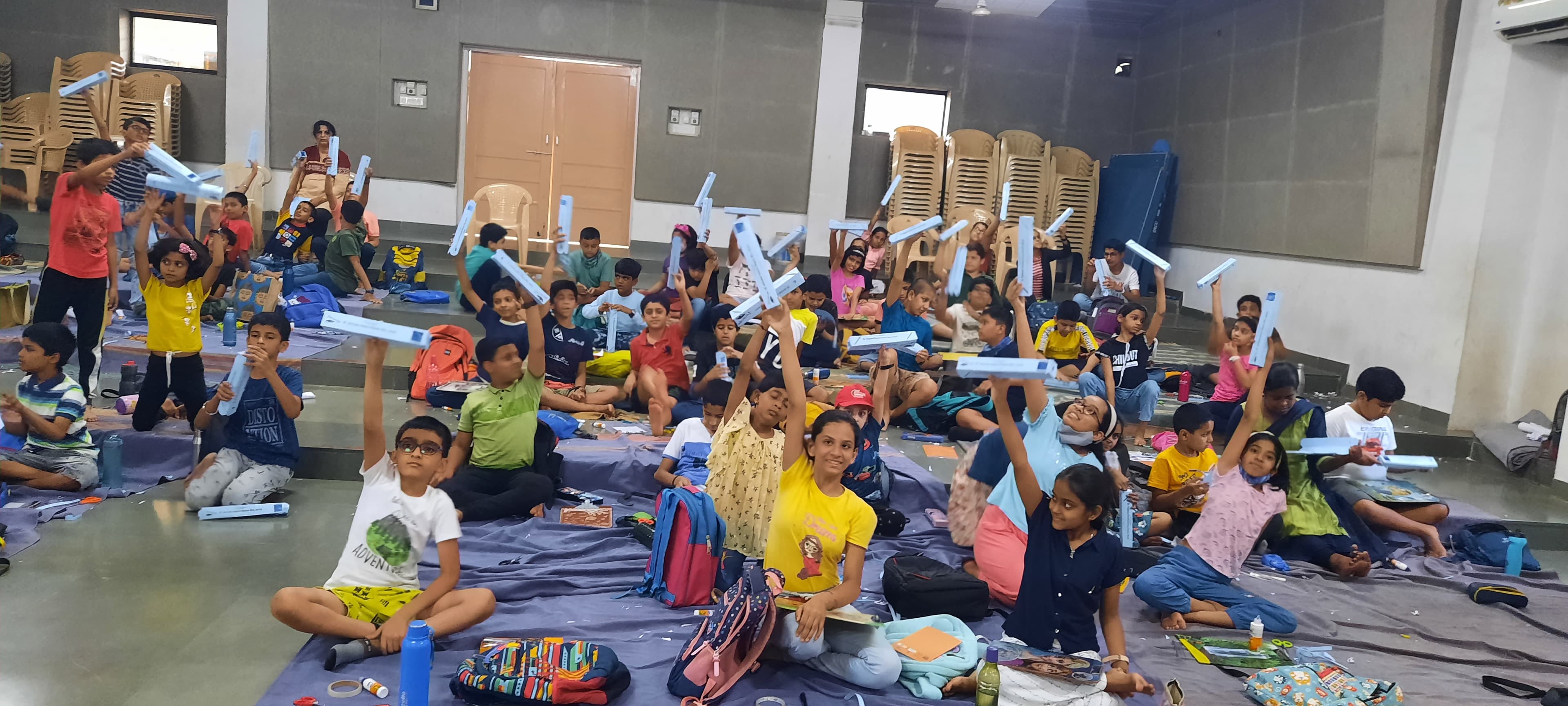 High energy — multiple children at different stations, variety of materials on tables